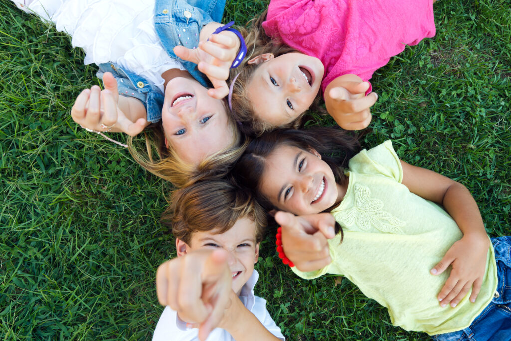Group of children smiling and laughing in the grass
